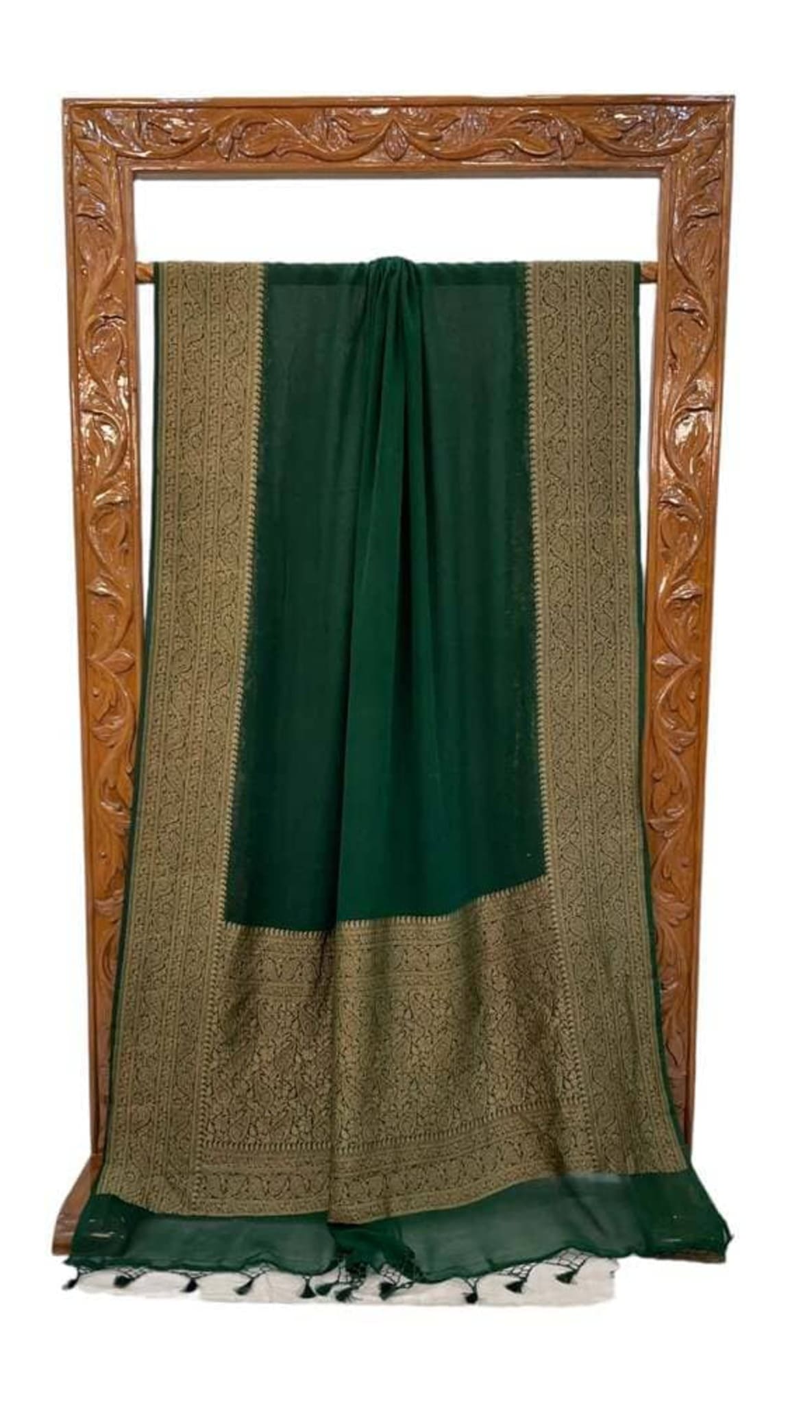 Green georgette saree folded, featuring gold zari border panels and patterned detailing at end