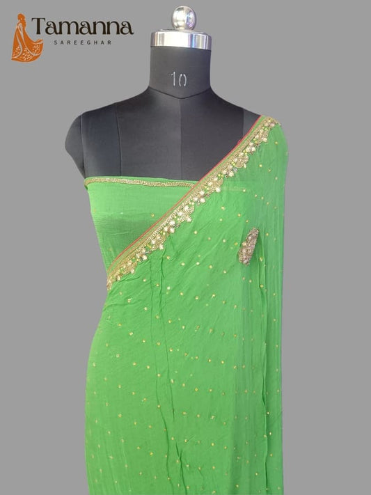 Green chiffon saree with diagonal gold-toned border and small stone accents