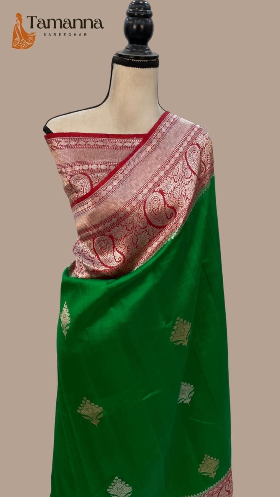 Green silk saree with pink woven pallu, all-over motifs, and gold accents, draped on mannequin