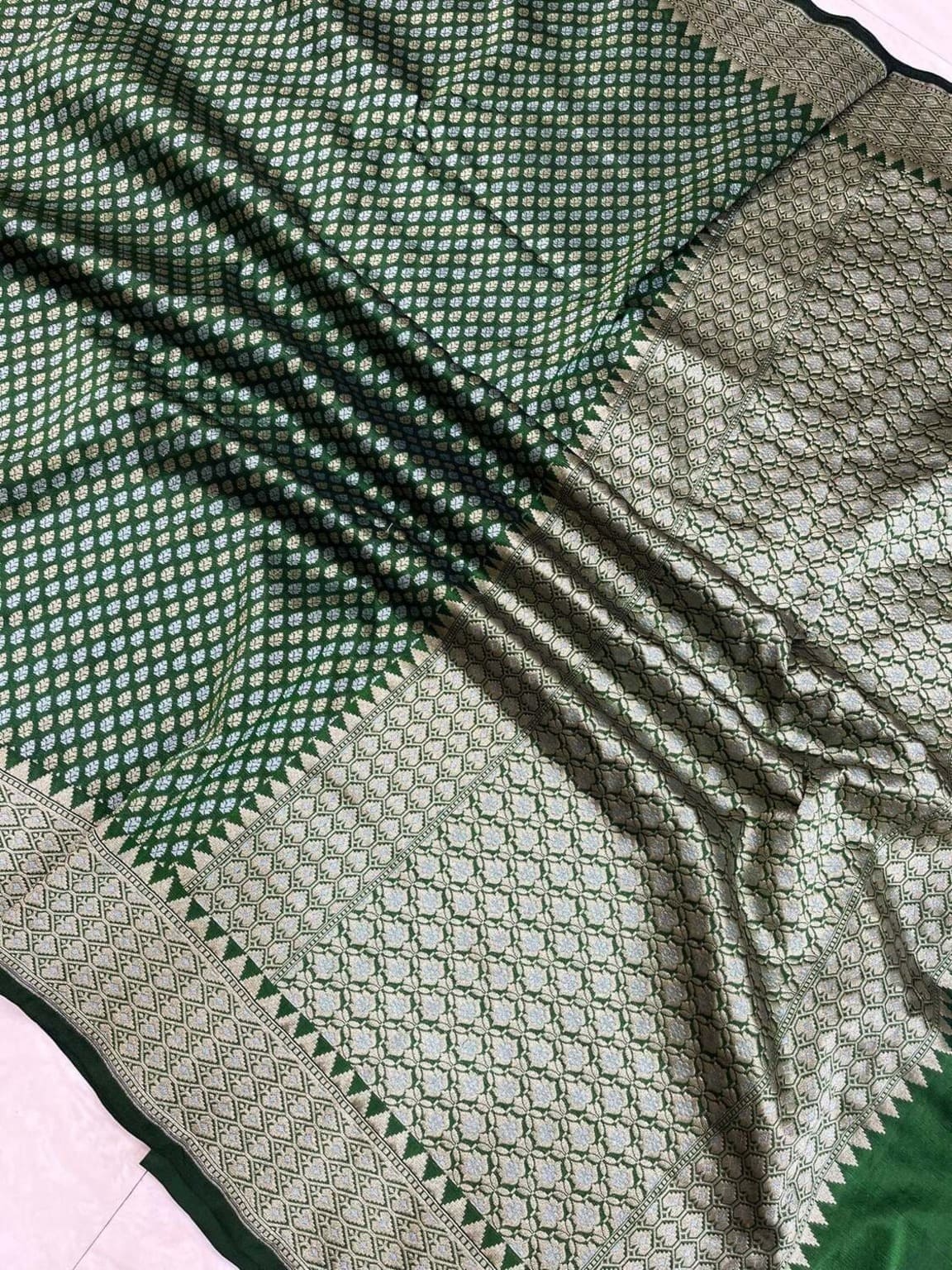Green silk saree close-up showing gold zari stripes and dotted motifs