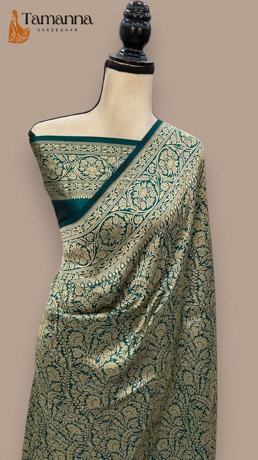 Teal-green silk saree with gold vine motifs and contrast border, shown on mannequin