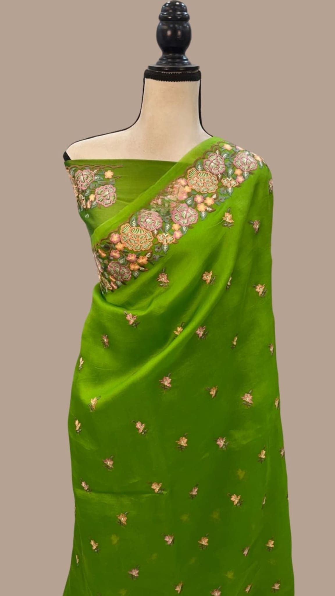 Green organza Banarasi saree draped with floral sprig pattern and embroidered border