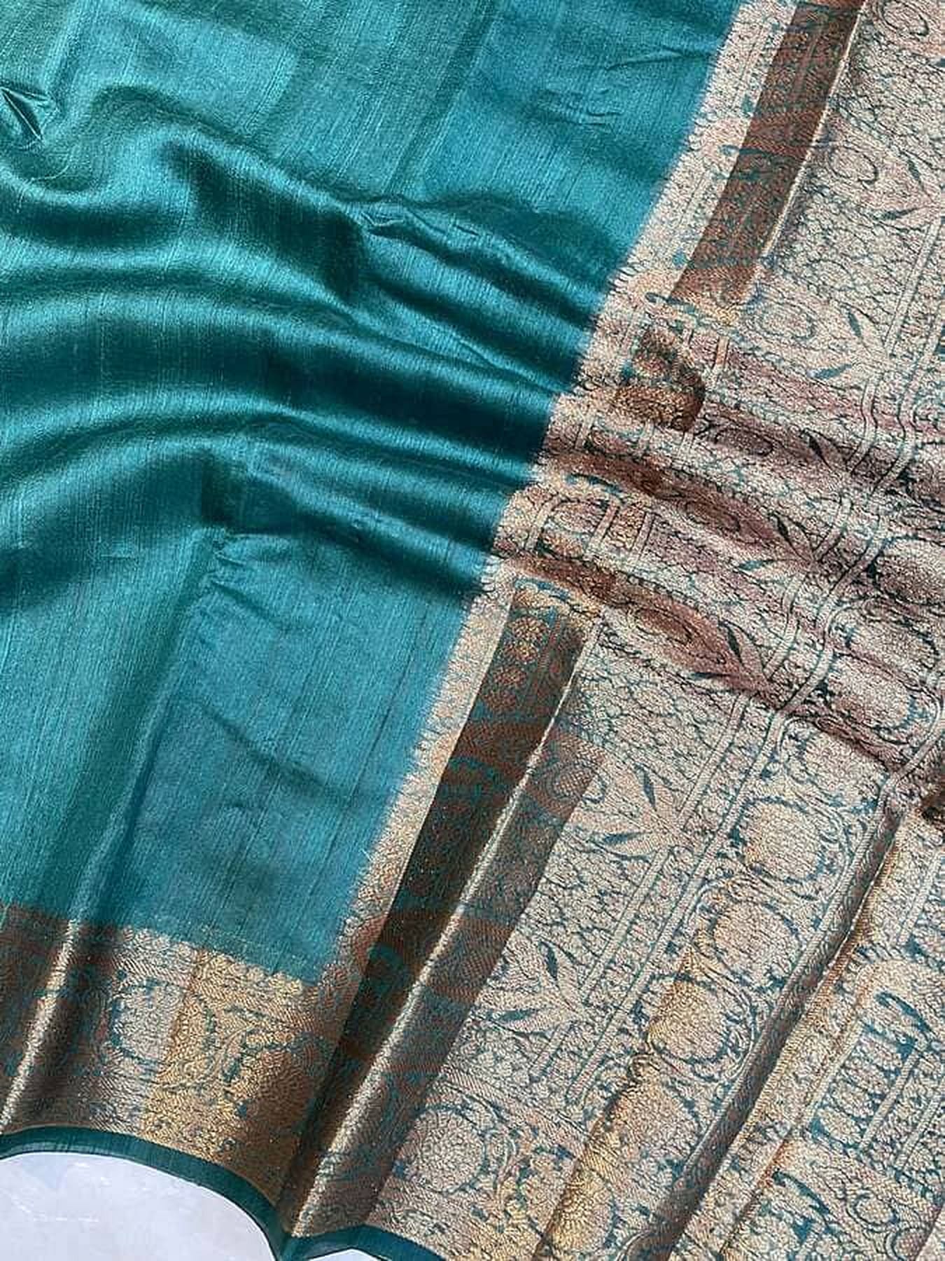 Teal-green saree fabric with wide beige-gold border and motif details