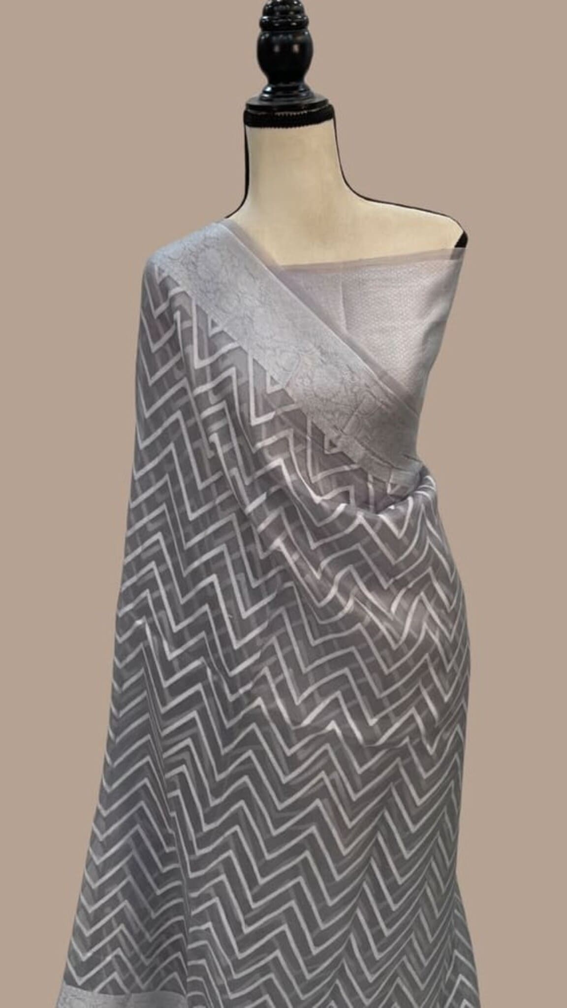 Grey saree drape with repeating chevron pattern and satin-like border