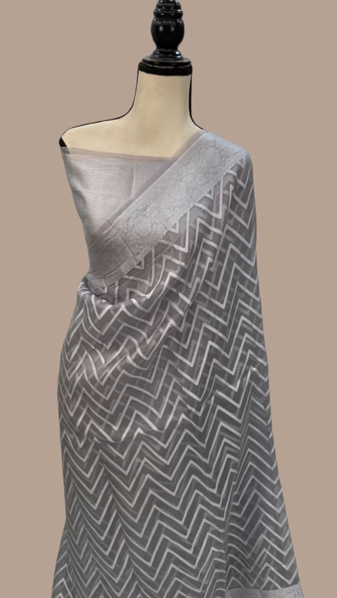 Grey Banarasi saree with zigzag border and woven chevron pattern on drape