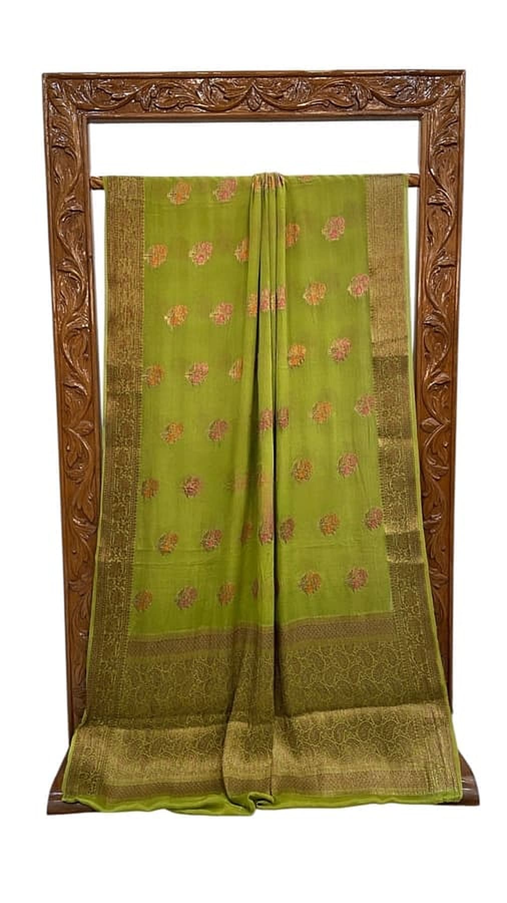 Green saree draped on frame, gold edge border with scattered pink floral motifs