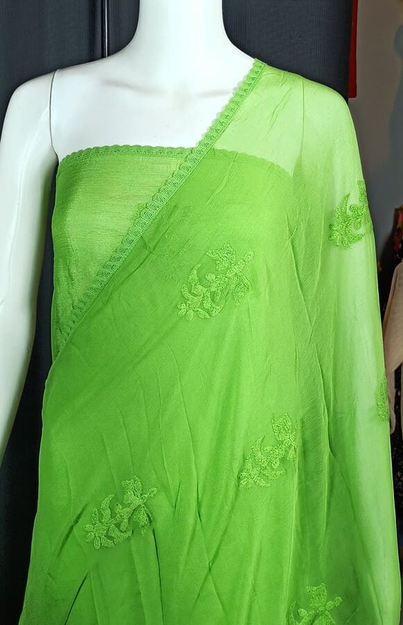 Green chiffon saree with floral threadwork motifs along the drape border