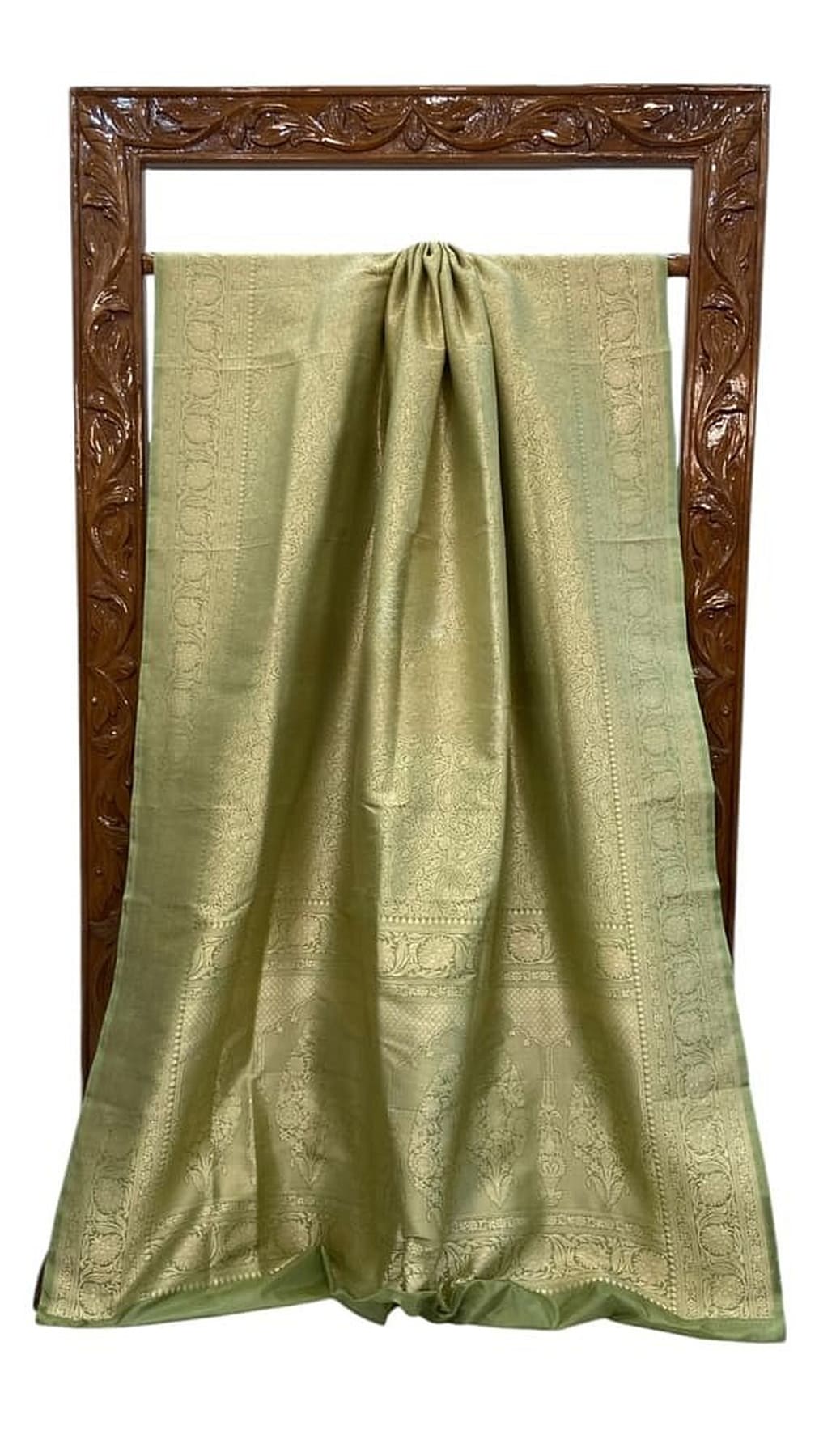 Green silk saree folded flat, textured weave with brocade motifs and border