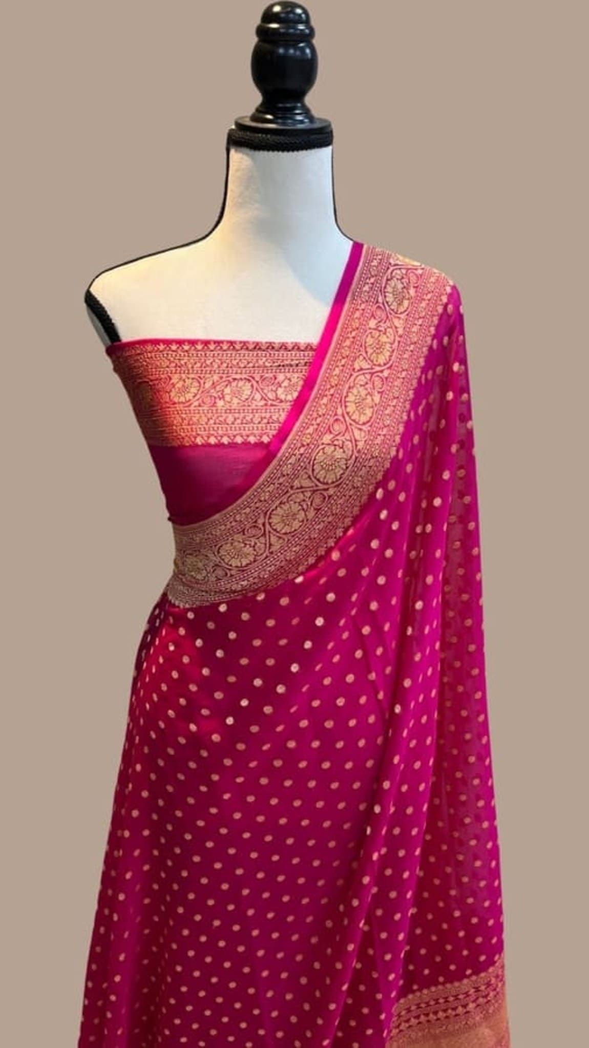 Hot pink saree with gold zari border and dotted texture, pallu shown on mannequin