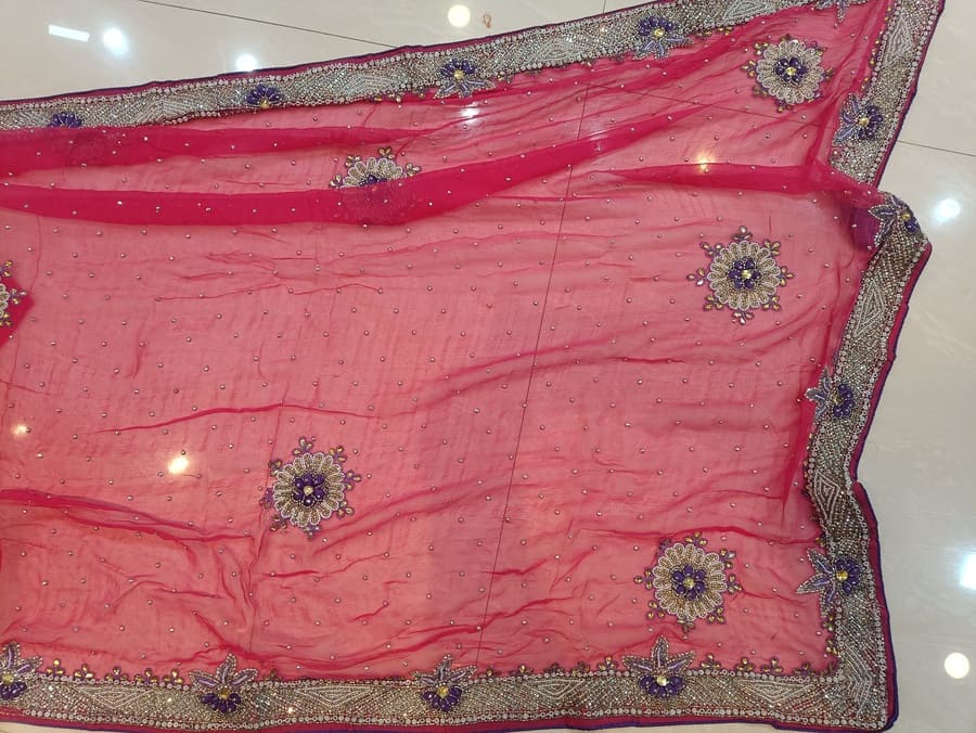 Hot pink chiffon saree close-up with pearl floral motifs and silver embroidered edge