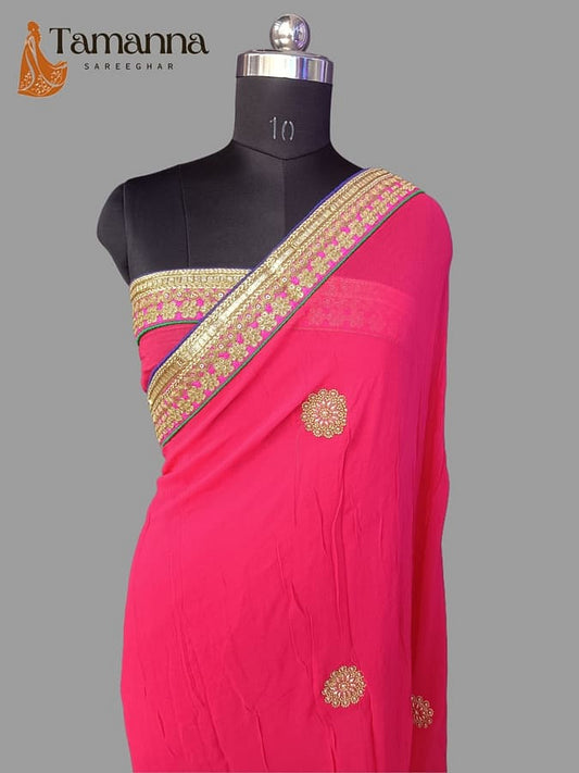 Hot pink georgette saree with gold border and jeweled round embellishments on drape