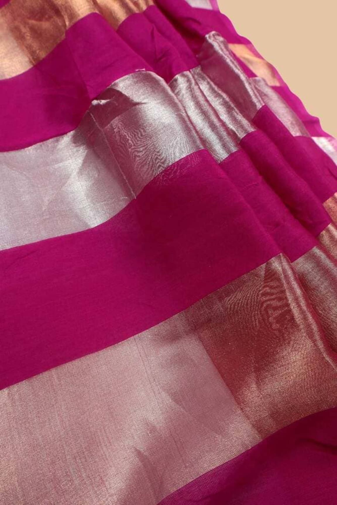 Hot pink tissue saree border with silver zari bands and woven texture close-up