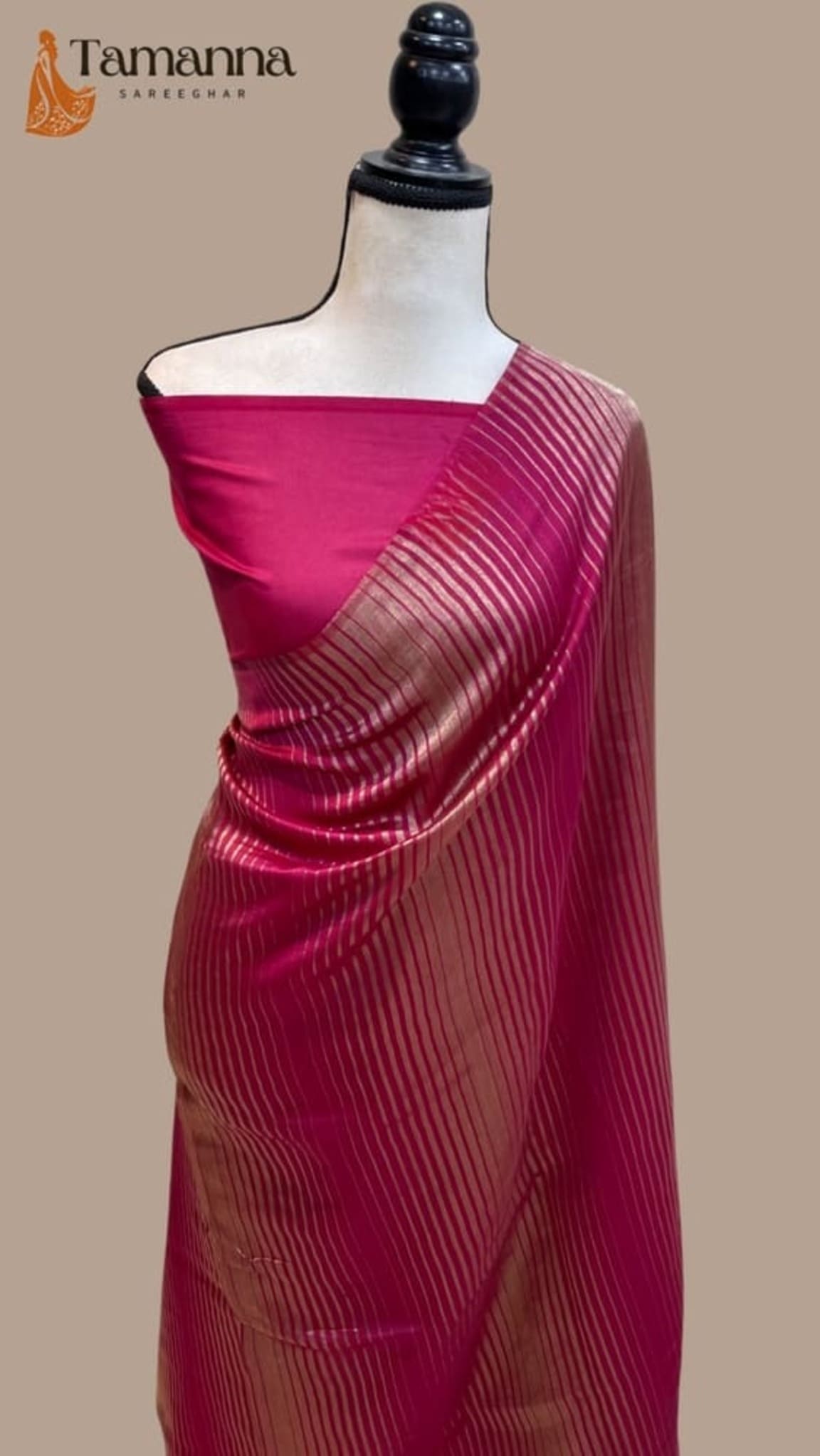 Hot pink Banarasi tissue saree draped on mannequin with striped pallu