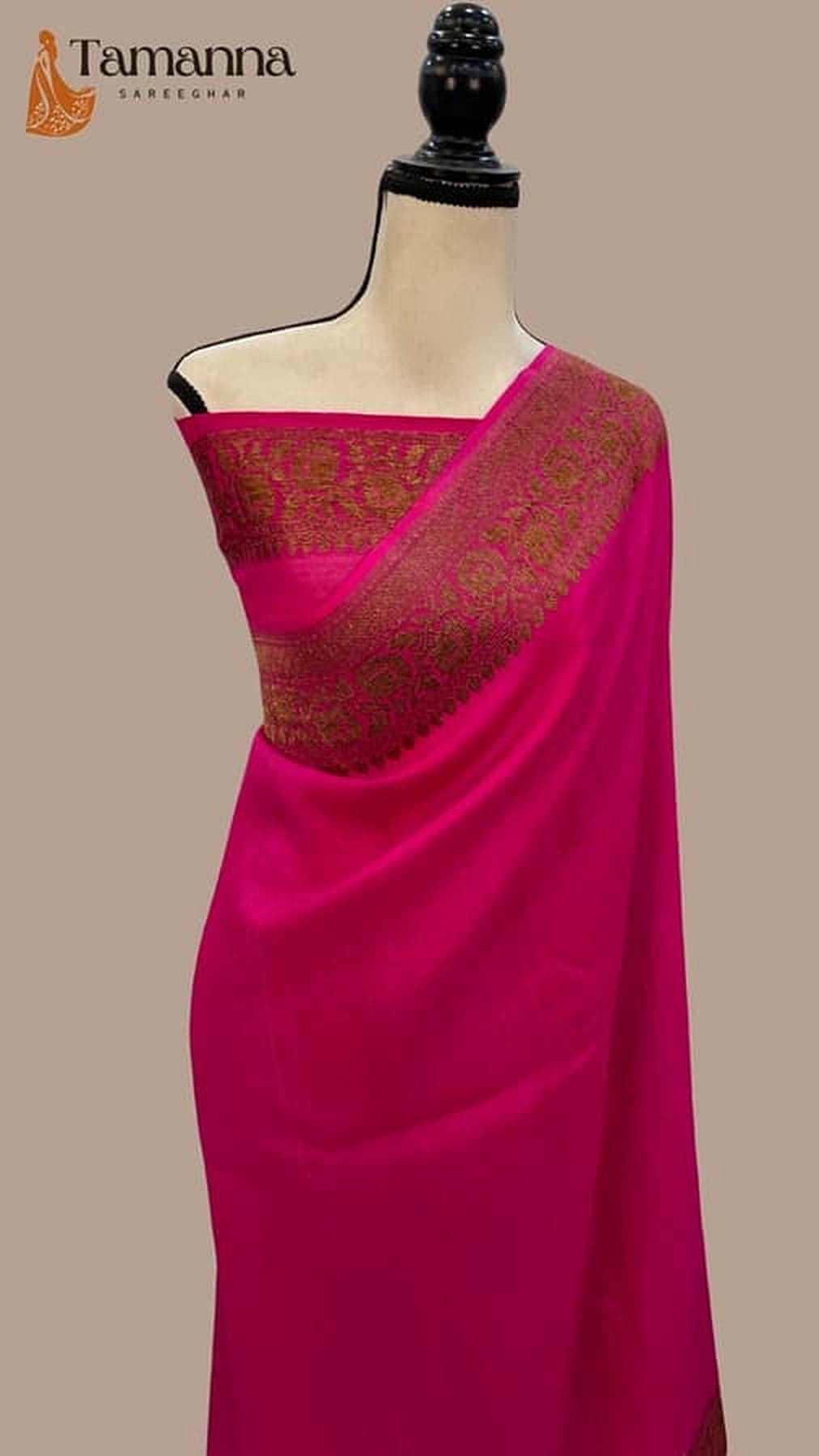 Hot pink draped saree on mannequin with gold-toned pallu and border detail