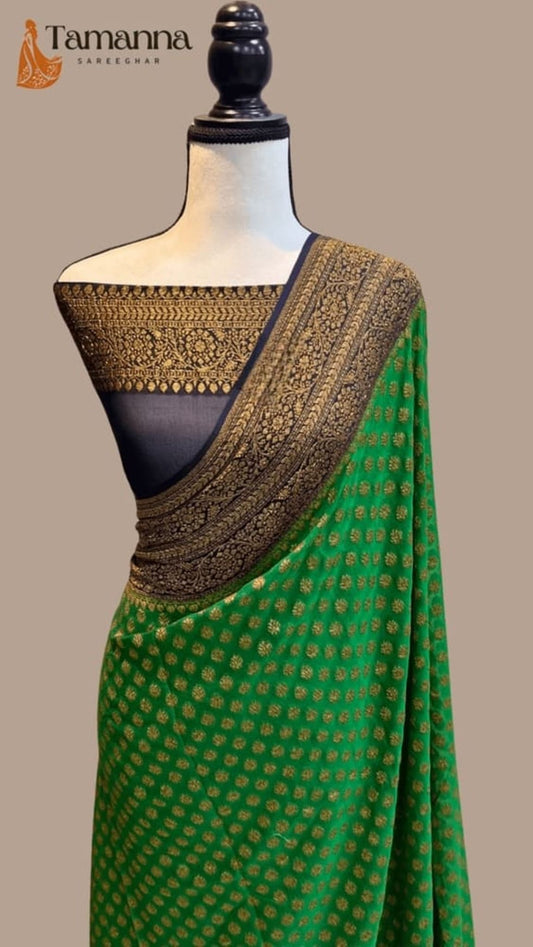 Green saree drape with gold zari border, dark pallu panel, and small motifs