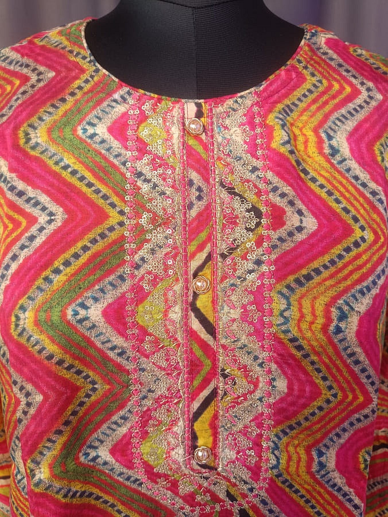 Close-up of hot pink kurta with multicolor zigzag pattern, gold-toned buttons