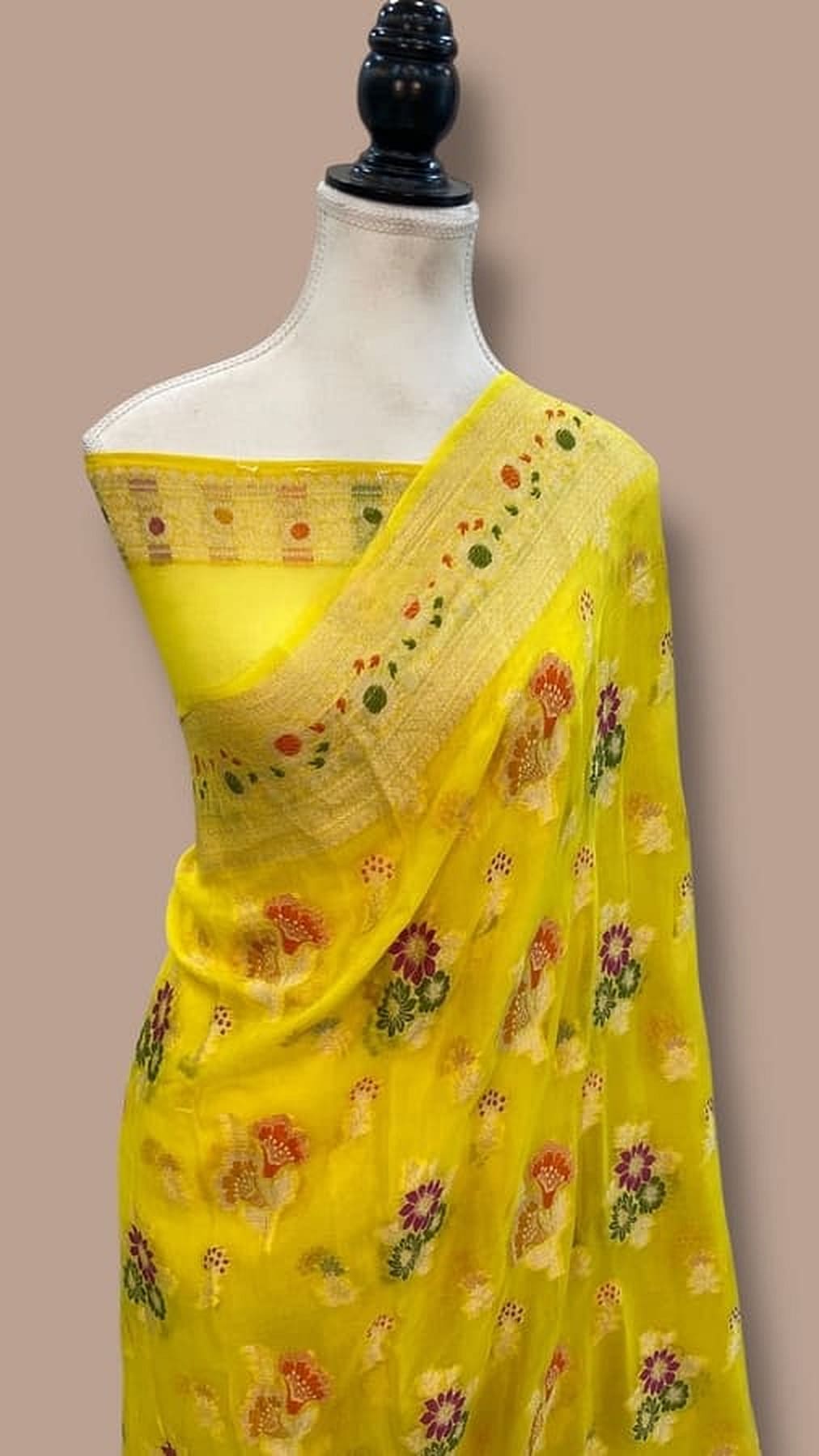 Lemon yellow Banarasi saree on mannequin, floral motifs across pallu and body