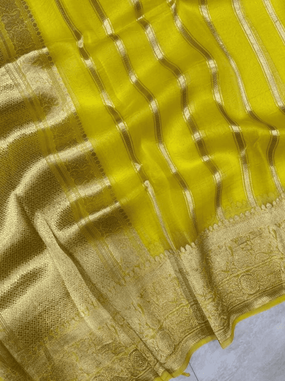 Lemon yellow saree close-up with gold zari stripes and embellished border
