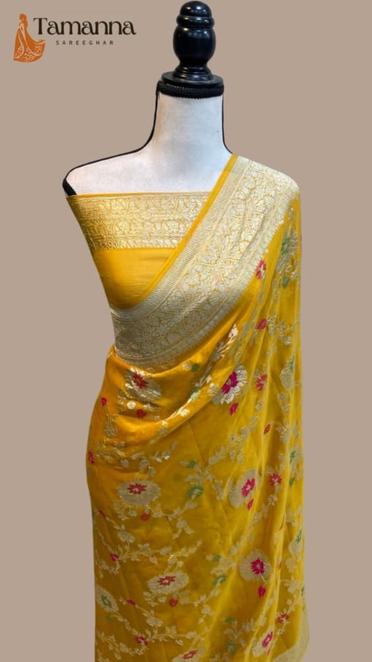 Yellow saree with gold pallu and floral allover motifs, draped on mannequin