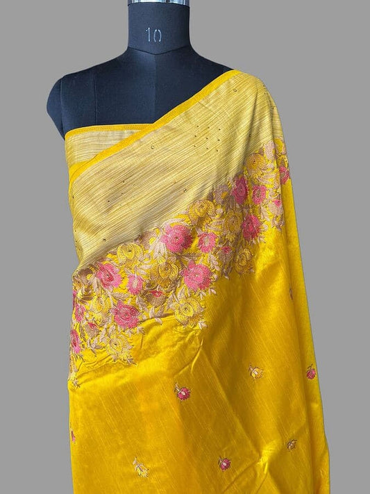 Yellow silk saree drape with pink floral thread work and gold-toned border
