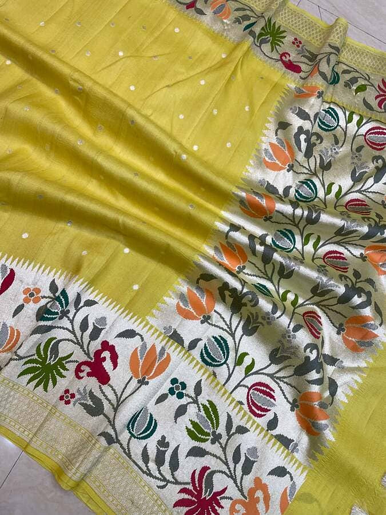 Mango-yellow saree border close-up with floral vine motifs and white stripes