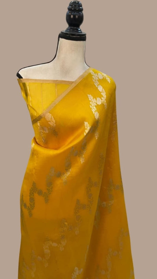 Yellow Banarasi-style saree with gold motifs, draped on a mannequin