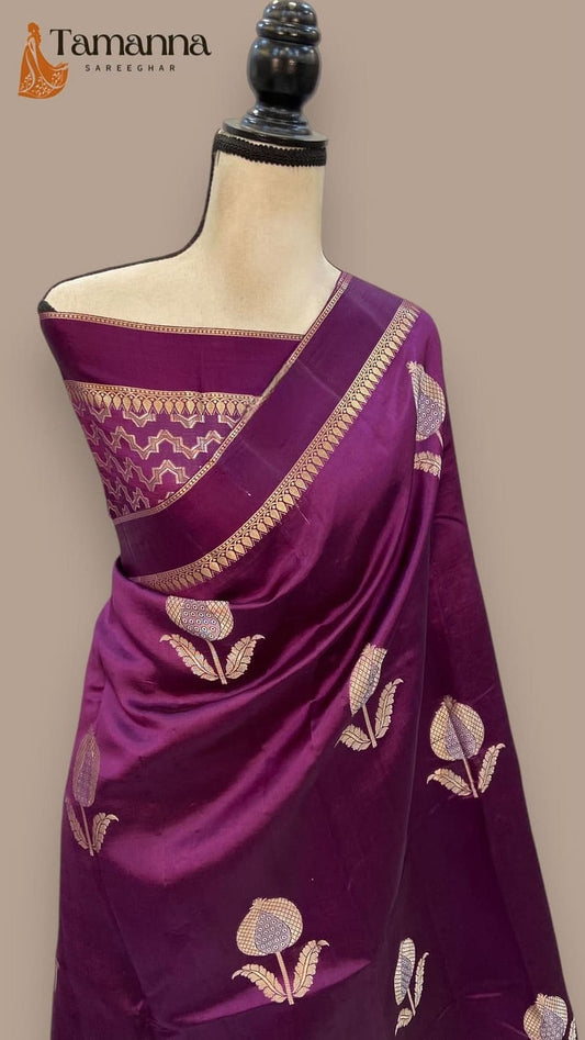 Magenta silk saree on mannequin with gold zari border and patterned leaf motifs