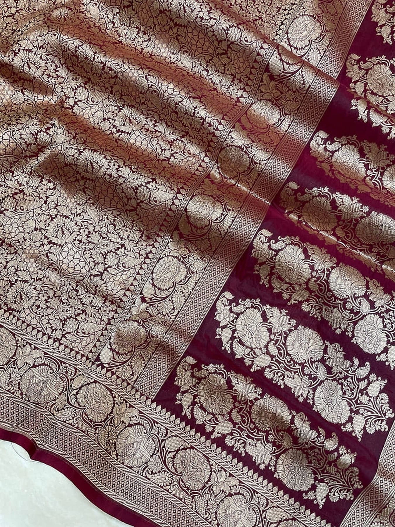 Banarasi silk saree fabric close-up, mauve brocade field with maroon patterned border