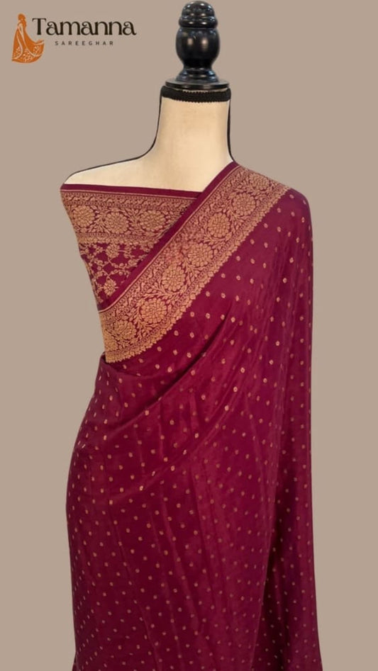 Maroon saree with gold zari diagonal border and dotted weave, draped on mannequin