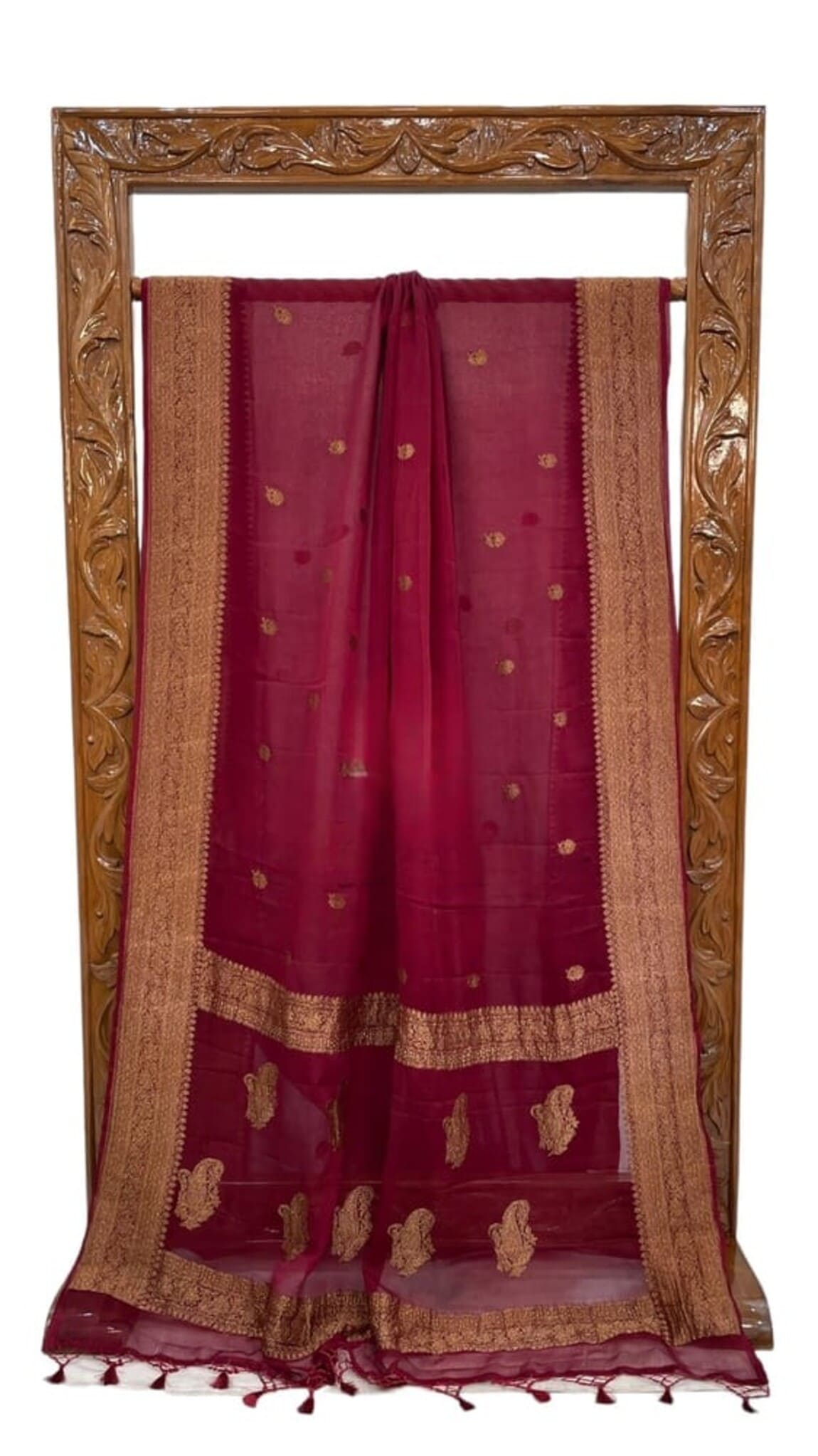 Maroon saree laid flat with gold zari border, ornate pallu, tasselled edge