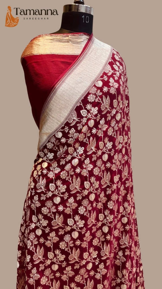Maroon saree with cream-gold border and dense floral pattern on the body