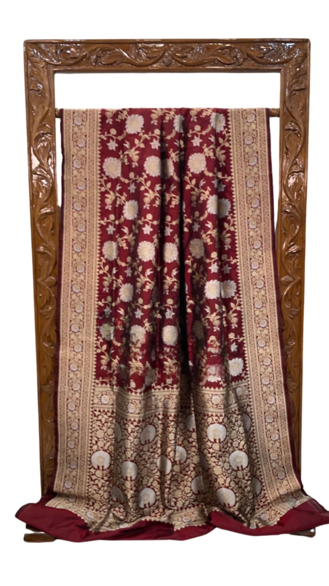 Maroon silk saree folded view with ornate gold border and floral allover design