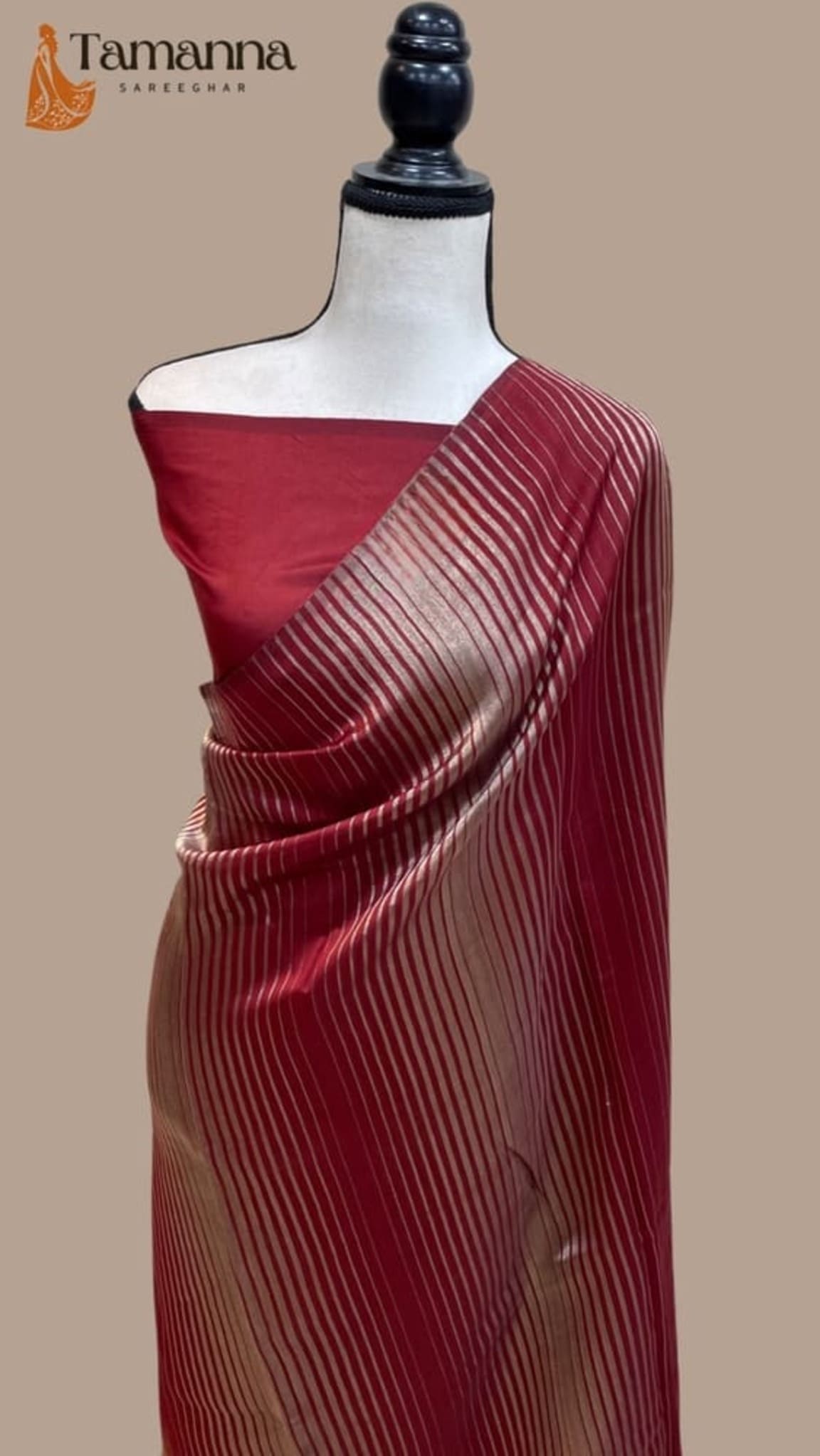 Maroon saree on mannequin with diagonal striped pallu and gold border detail