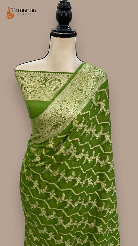 Green chiffon saree on mannequin with gold pallu border and zigzag vine motifs