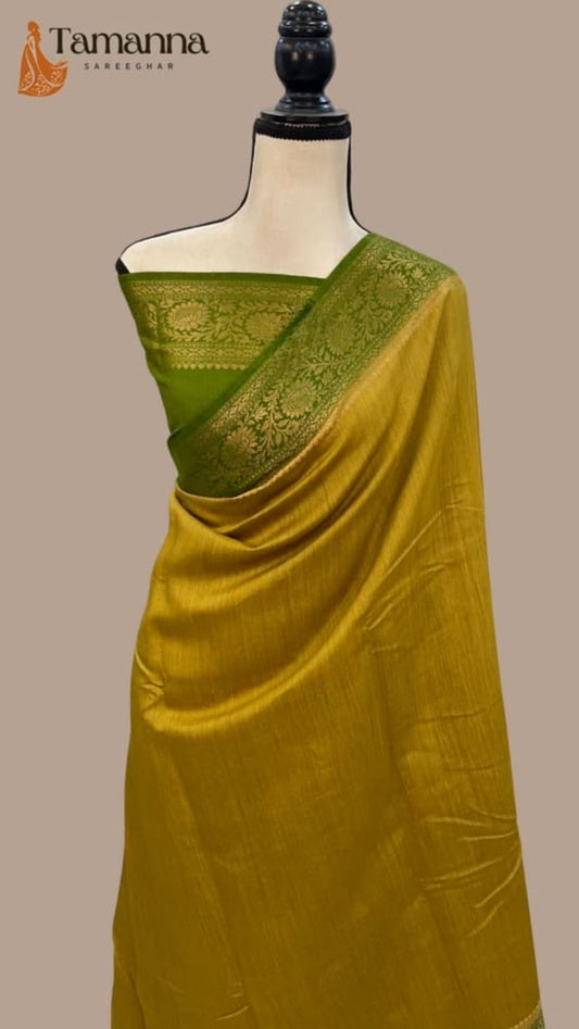 Yellow Banarasi saree draped on mannequin with green pallu border and woven motifs