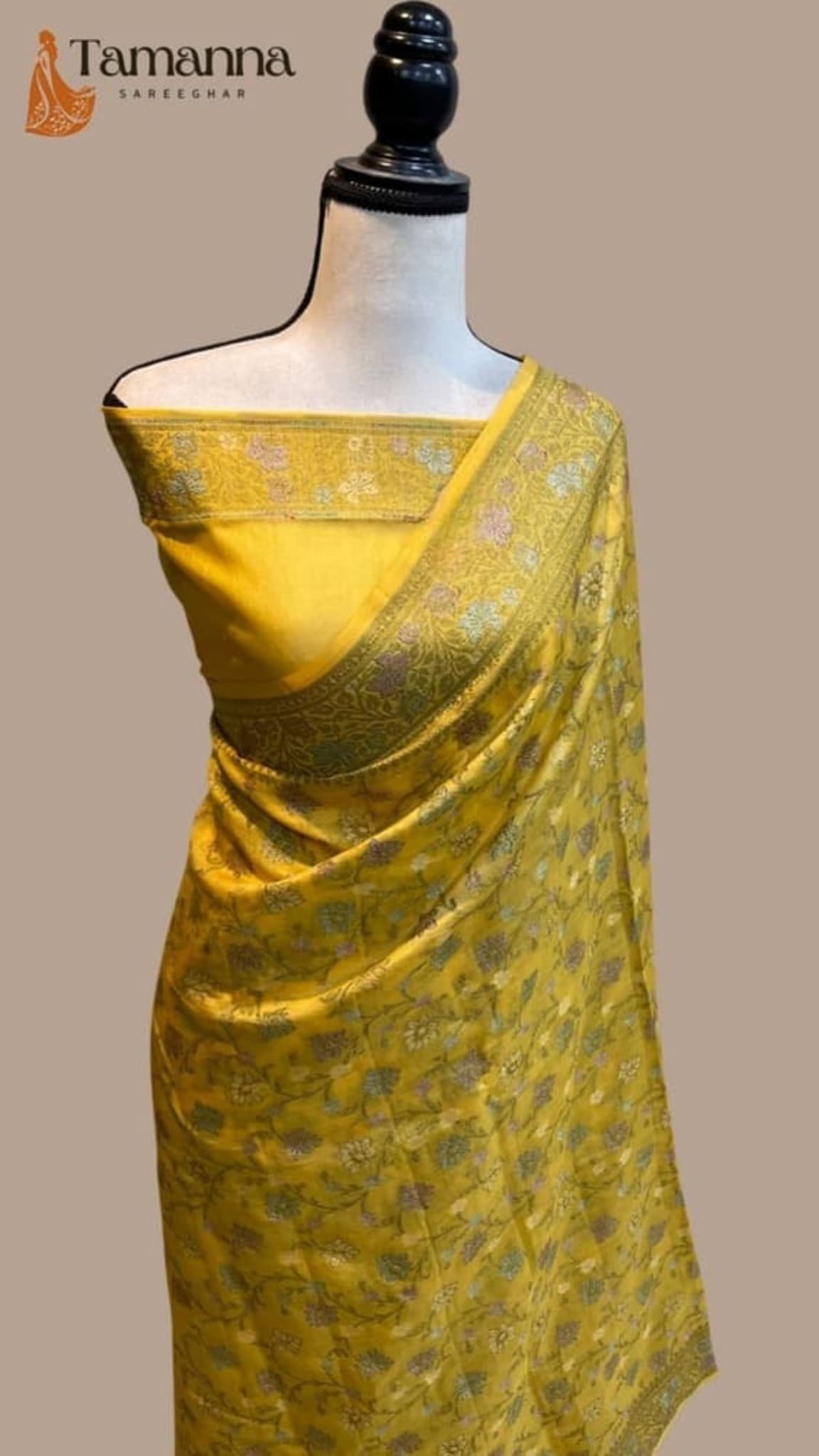 Mustard-yellow Banarasi saree draped on mannequin with patterned fabric and zari trim
