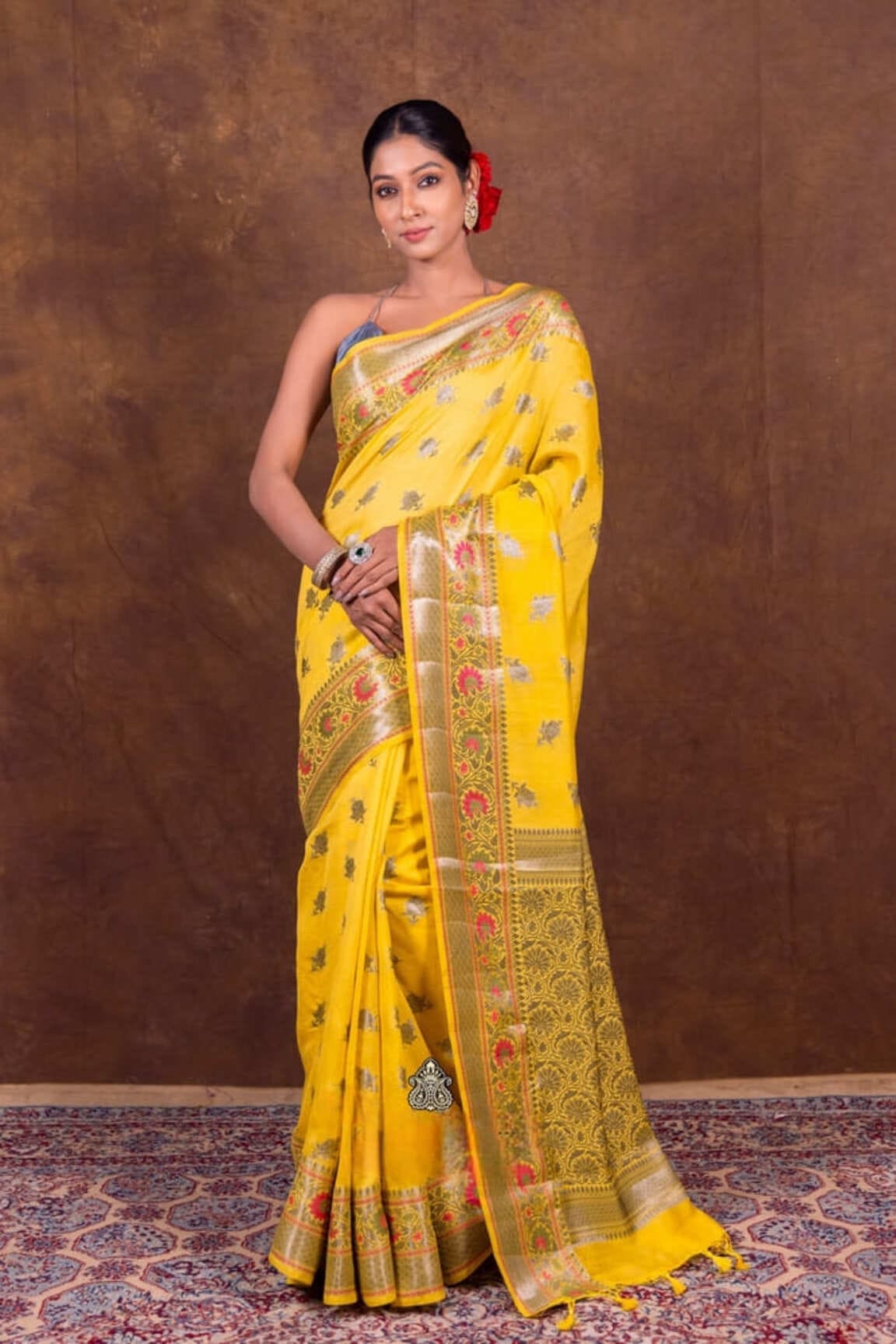Mustard yellow Banarasi saree with red-gold border and patterned fall, side drape