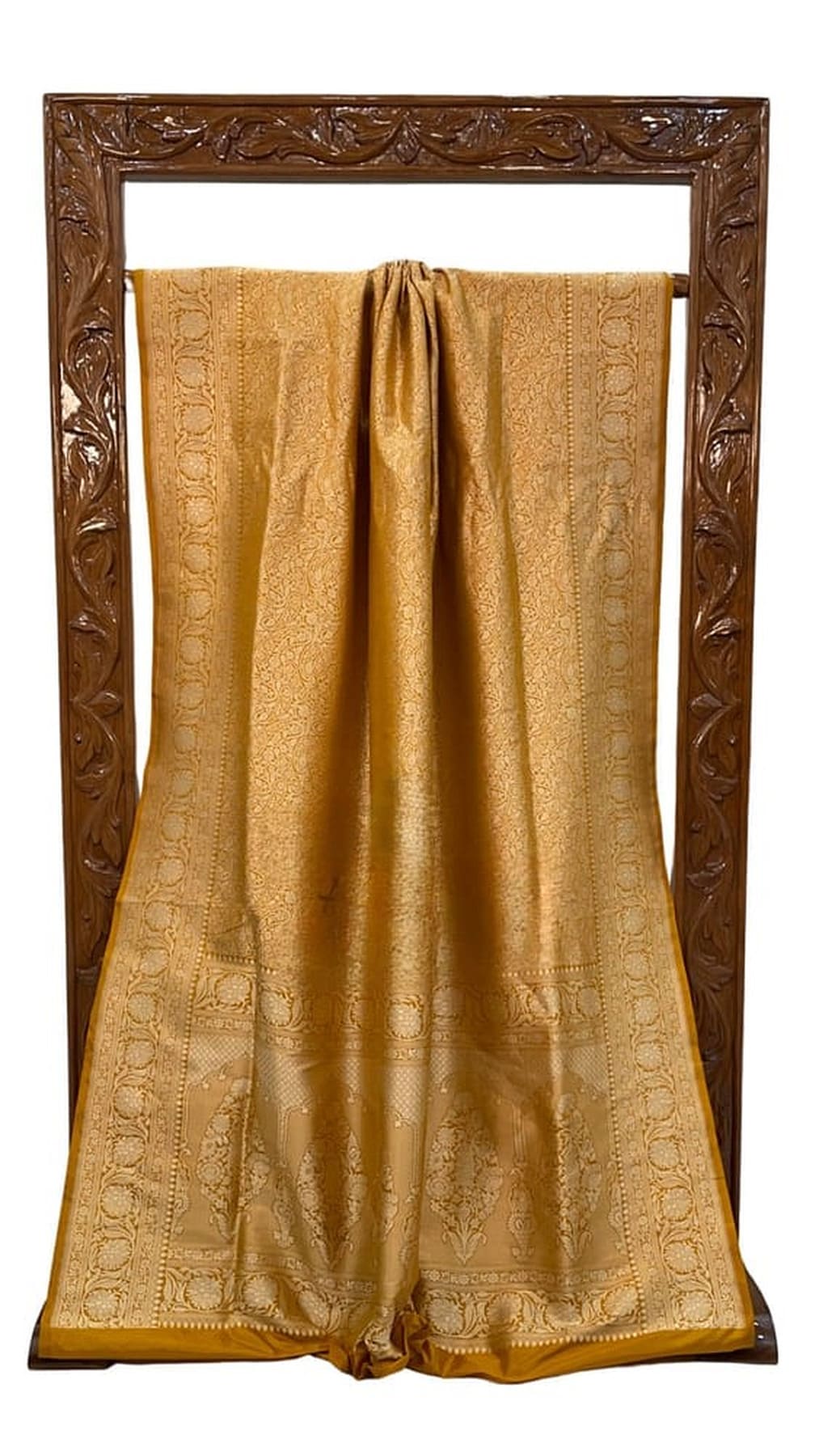 Gold silk saree with brocade border and central woven motif panels, draped