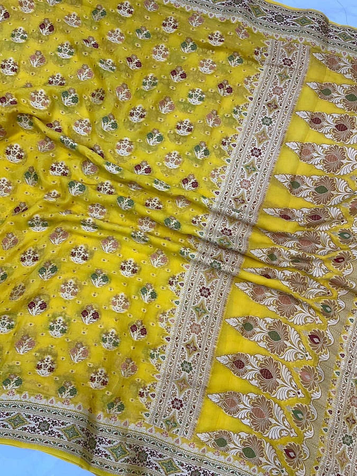 Mustard yellow saree close-up with silver border and floral corner panel design