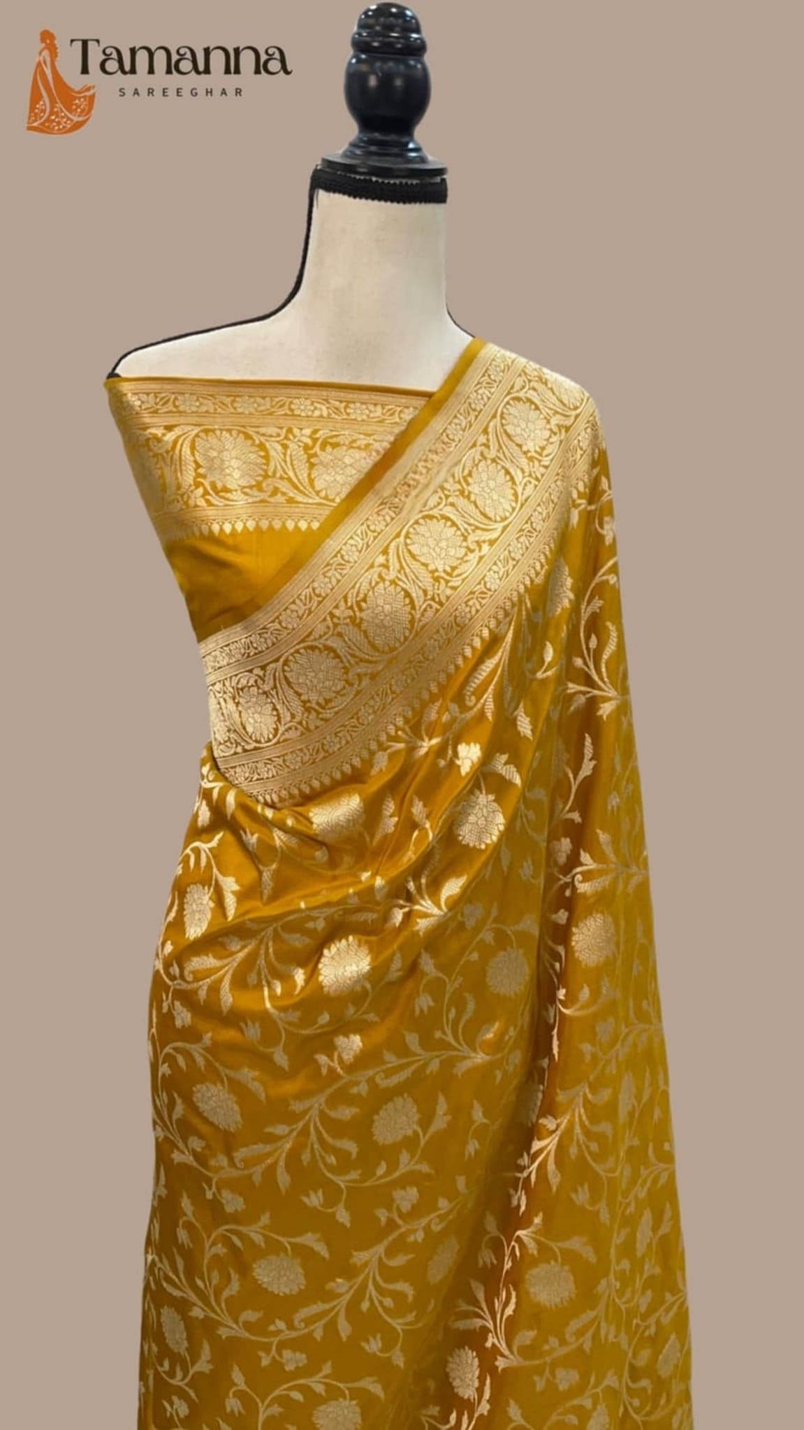 Mustard silk saree with all-over jaal design and ornate gold border, draped on mannequin.