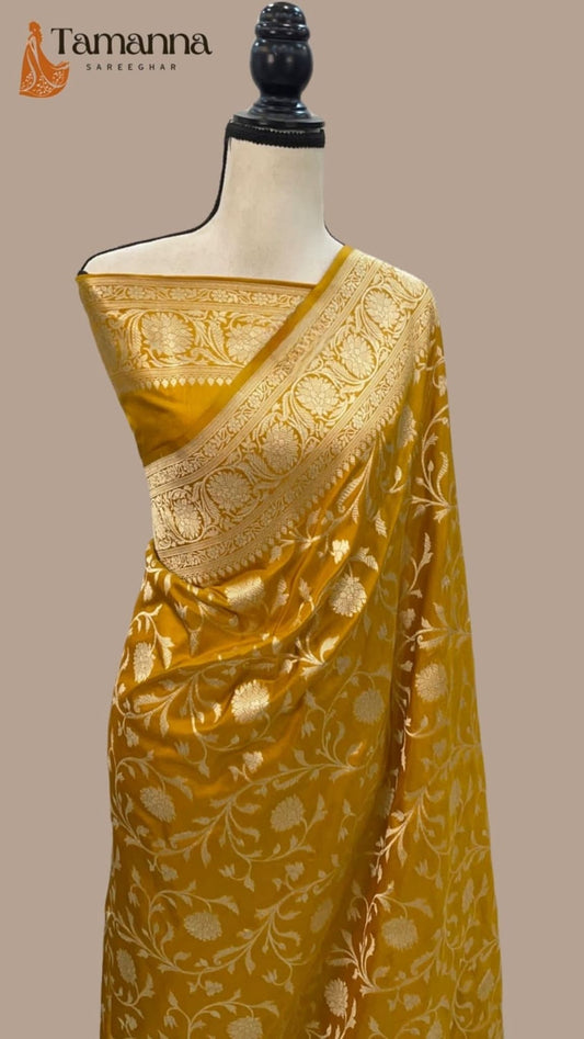 Mustard silk saree featuring all-over jaal motifs and gold pallu detailing on mannequin.