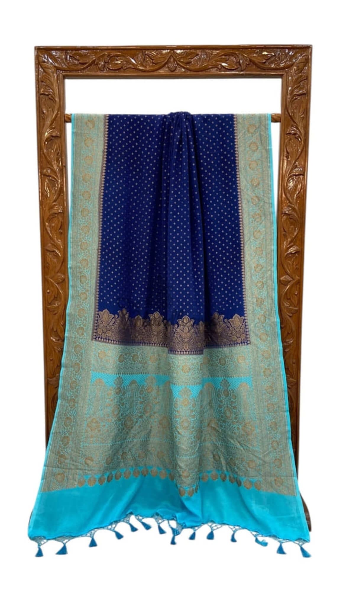 Folded navy blue saree with turquoise pallu panel, gold accents, tassel edge