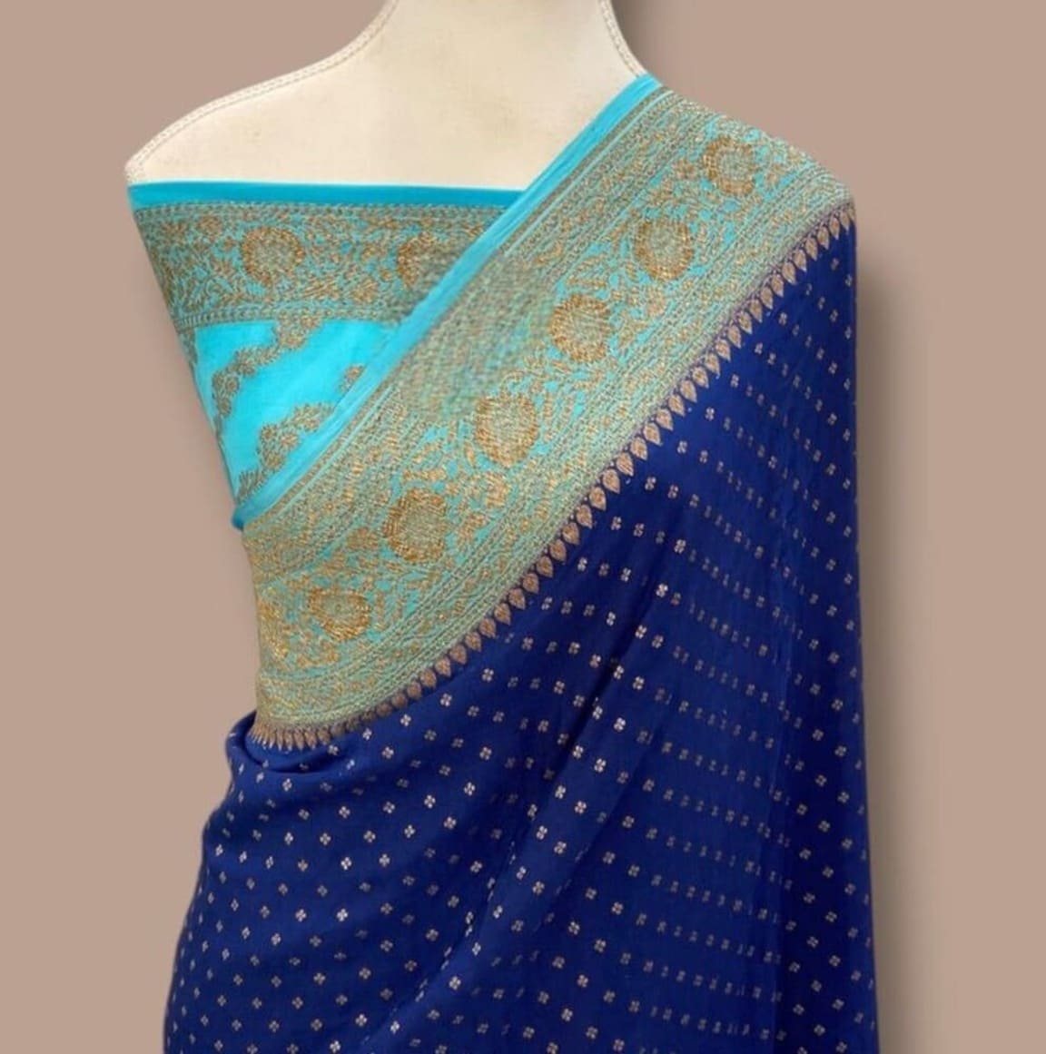 Mannequin-draped navy blue saree with turquoise border and textured gold pallu
