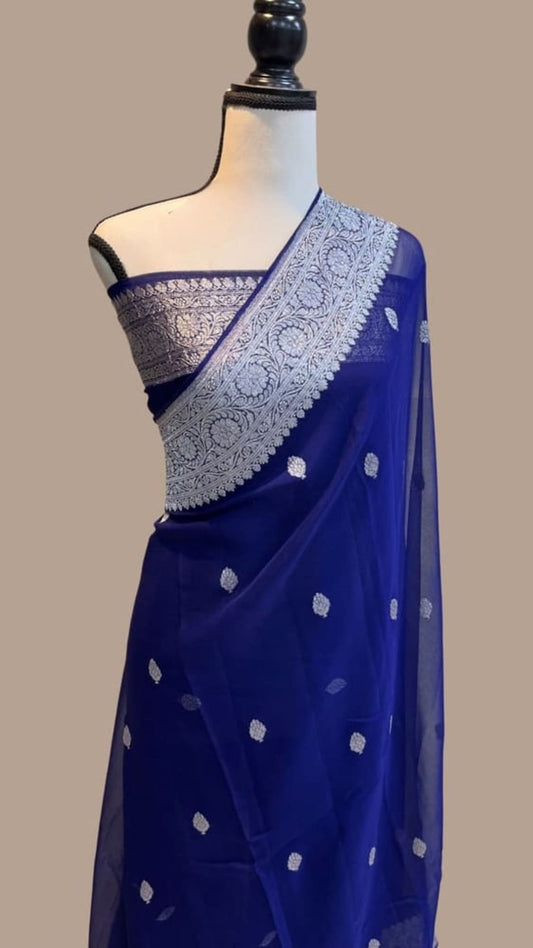 Navy blue saree draped on mannequin with silver patterned border and dotted work