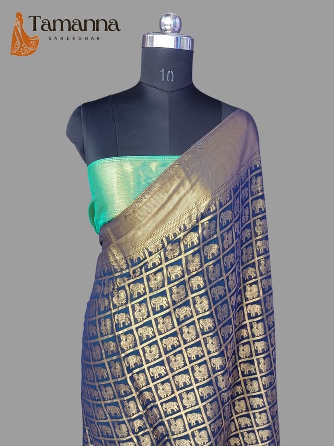 Navy chiffon saree with gold zari border, patterned body, and green pallu panel