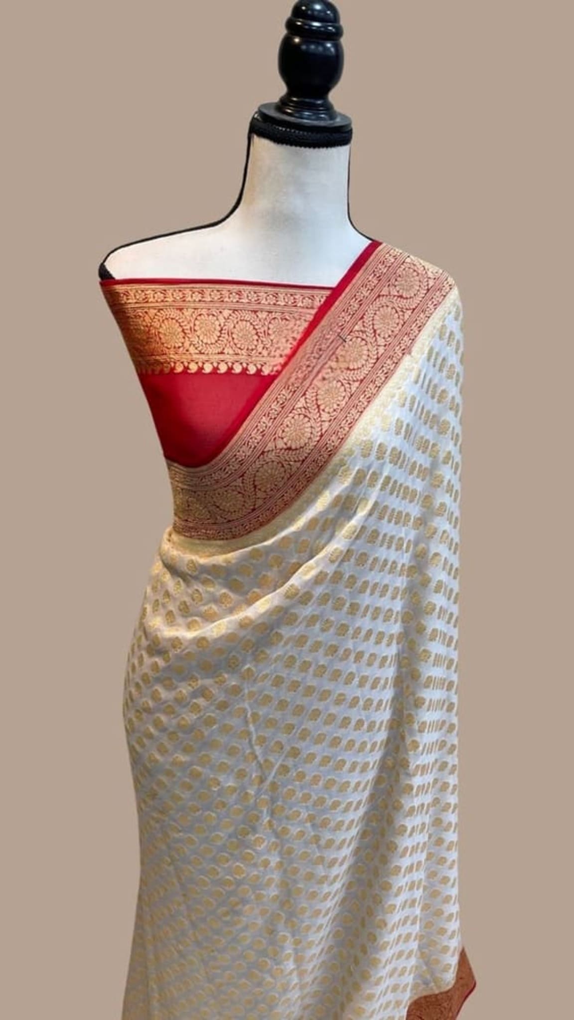 Off-white saree with gold zari dots and red-gold woven border, draped on mannequin