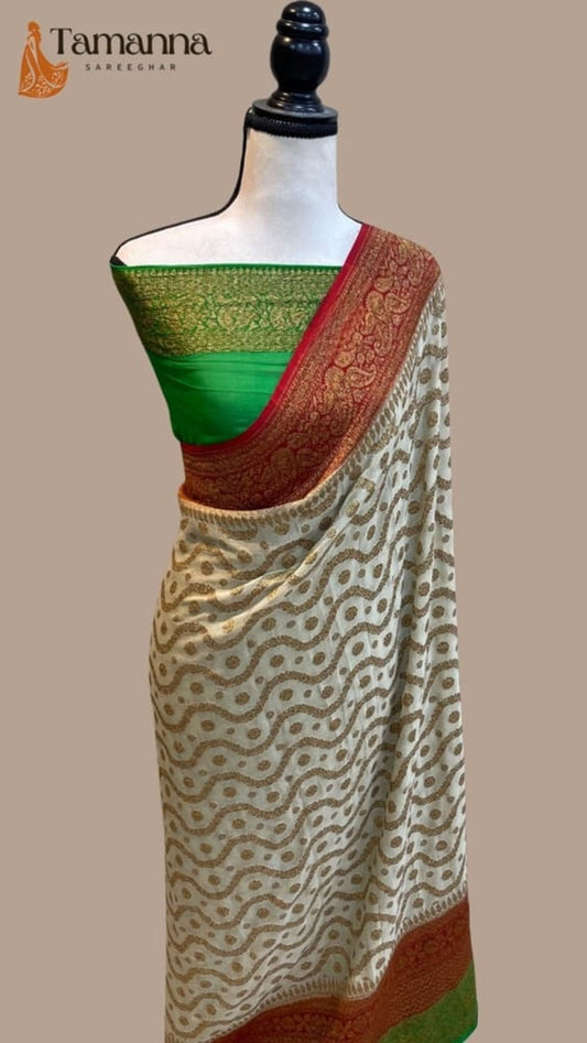 Off-white handloom saree draped on mannequin, green edge and maroon zari pallu