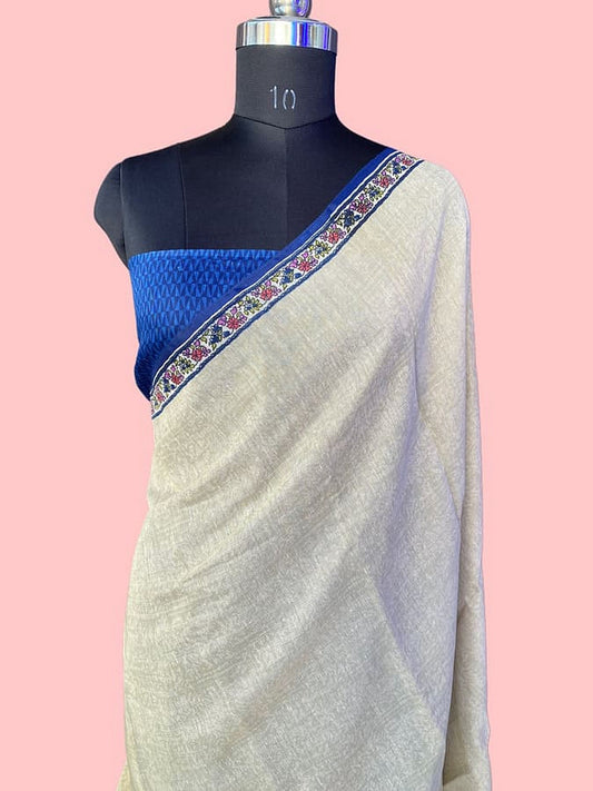 Off-white pure silk saree draped on mannequin, blue border with trim