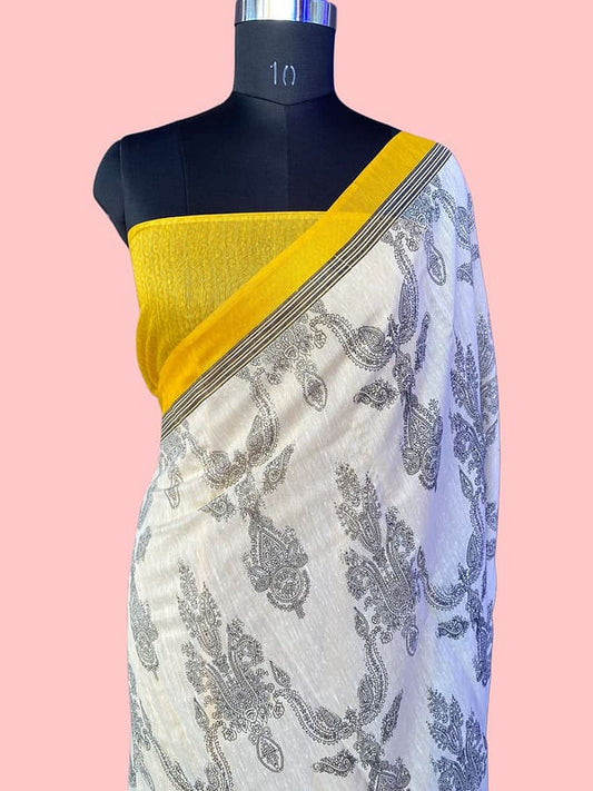 Off-white silk saree with blue-gray paisley print and wide yellow-gold border