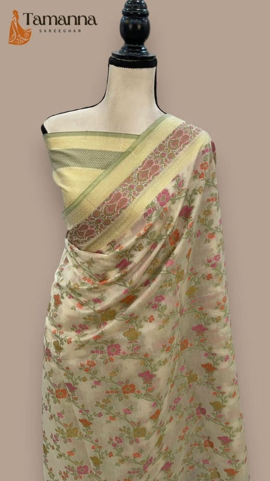 Cream cotton saree draped on mannequin, floral print with gold and patterned pallu border